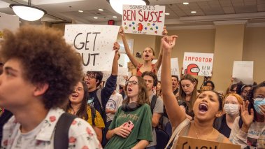 Student protestors wave signs and chant as they enter Sen. Ben Sasse open forum discussion at Emerson Alumni Hall during in Gainesville