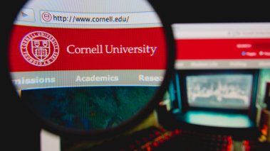 Cornell University homepage on a monitor screen through a magnifying glass