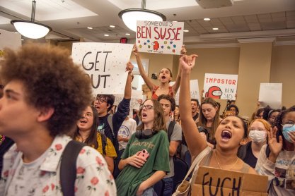 Student protestors wave signs and chant as they enter Sen. Ben Sasse open forum discussion at Emerson Alumni Hall during in Gainesville