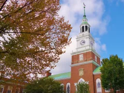 With a tree in fall colors filling most of the left half of the frame this is a nice view of the library bell tower and blue sky on the campus of Dartmouth College in Hanover, New Hampshire.