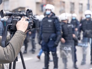 A cameraman films riot police at a protest