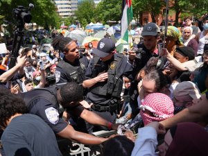 George Washington University Police officers tussle with protesters who tried to raise the Palestinian flag on the campus flagpole