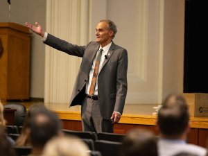 UW-La Crosse professor Joe Gow gestures to an audience in an auditorium on campus