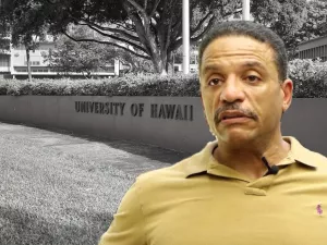 Law professor Ken Lawson with the entrance sign for the University of Hawai'i at Manoa in the background