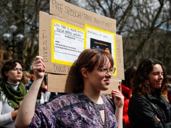University of Michigan PhD student Allison Cale, center, carries a sign that says Free Speech! Free Palestine! as students walk out to protest university administration's proposed disruptive activity policy at U-M's Diag in Ann Arbor on Thursday, April 4, 2024.