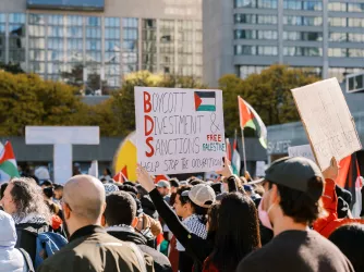 Protesters march in the city holding signs advocating for Boycott Divestment and Sanctions on October 28, 2023