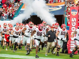 The Georgia Bulldogs and head coach Kirby Smart runs onto the field for the Capital One Orange Bowl on December 30 2023