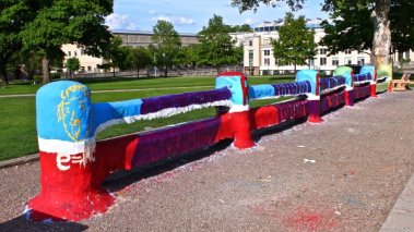 A fence on Carnegie Mellon University's campus, clearly colorfully painted over multiple times.