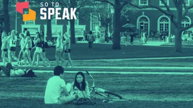 Students sitting on a blanket on a campus lawn.