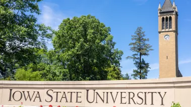 View of Iowa State University sign and campanile (central landmark) with green environment and blue sky. Popular collage of Engineering, Business, Management. Editorial