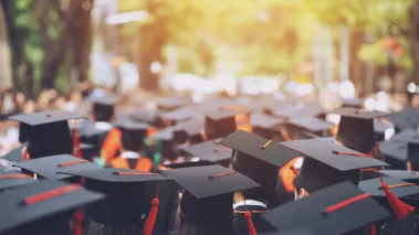 Commencement college graduates with red tassels