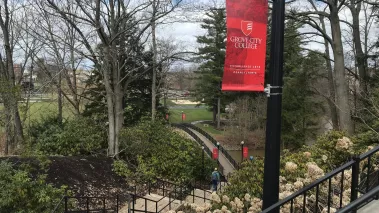 A student walks across Grove City College's campus in early spring