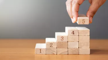 Hand building steps out of toy wood blocks