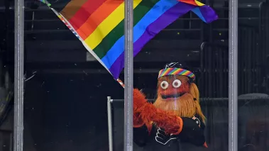 Philadelphia Flyers mascot Gritty waves a flag during Pride Night against the Pittsburgh Penguins