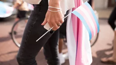 Person holding a trans pride flag 