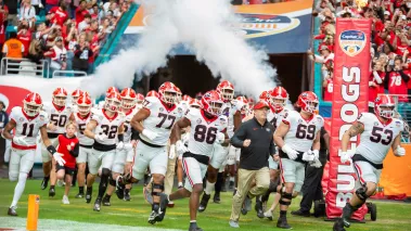 The Georgia Bulldogs and head coach Kirby Smart runs onto the field for the Capital One Orange Bowl on December 30 2023