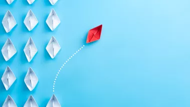 White paper ships on a blue background with a single red ship sailing away unique