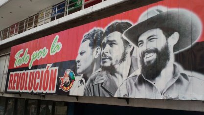 Propaganda poster in Havana, Cuba, circa 2012, featuring revolution-era photos of (left to right) Camilo Cienfuegos, Ernesto "Che" Guevara, and Fidel Castro.