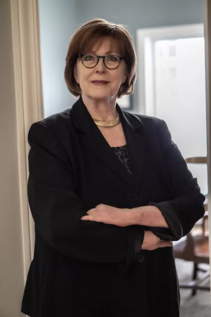 Iowa pollster J. Ann Selzer with arms crossed in her office