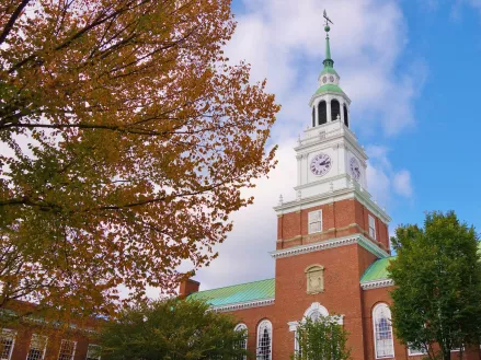 With a tree in fall colors filling most of the left half of the frame this is a nice view of the library bell tower and blue sky on the campus of Dartmouth College in Hanover, New Hampshire.