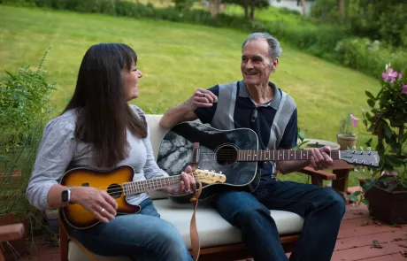 Joe Gow and wife Carmen Wilson playing music at home