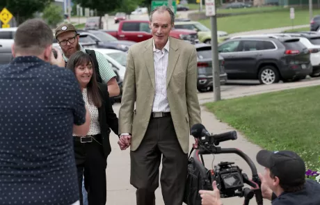 Videographer takes a tumble as former UW-La Crosse Chancellor Joe Gow and wife Carmen Wilson arrive at a disciplinary hearing on June 19 2024