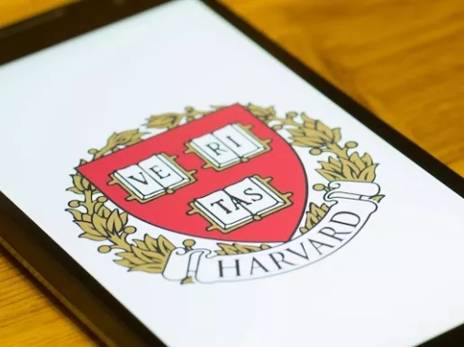 A Smartphone screen shows logo of Harvard University.