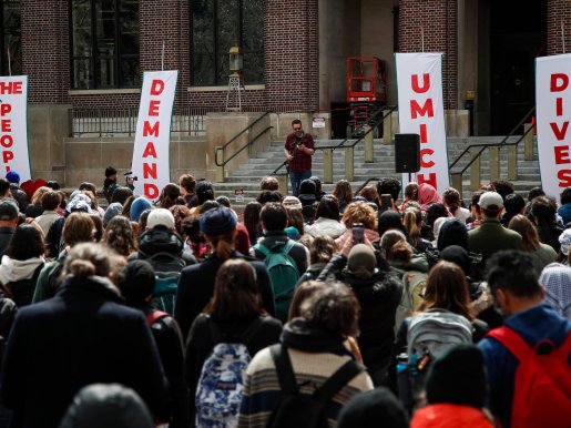 University of Michigan faculty David Zeglen speaks on stage as students walk out to protest proposed disruptive activity policy on April 4, 2024.