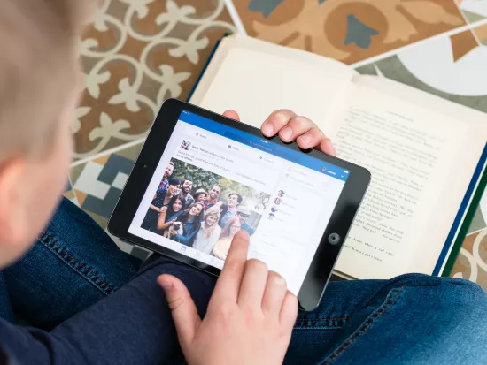 Boy sitting on the floor to read on a social network