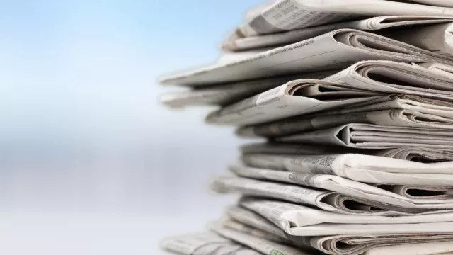 Stack of newspaper against a blurry background