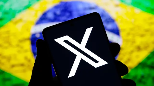 The X Twitter logo is displayed on a smartphone screen and the flag of Brazil in the background