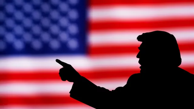 silhouette of Donald Trump against the background of the American flag.